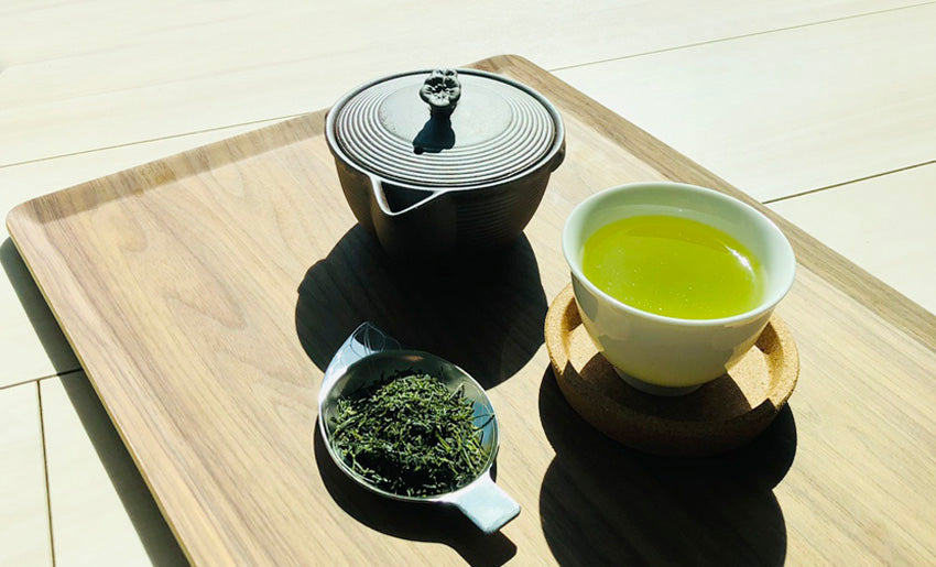 Japanese green tea in ceramic cup with teapot