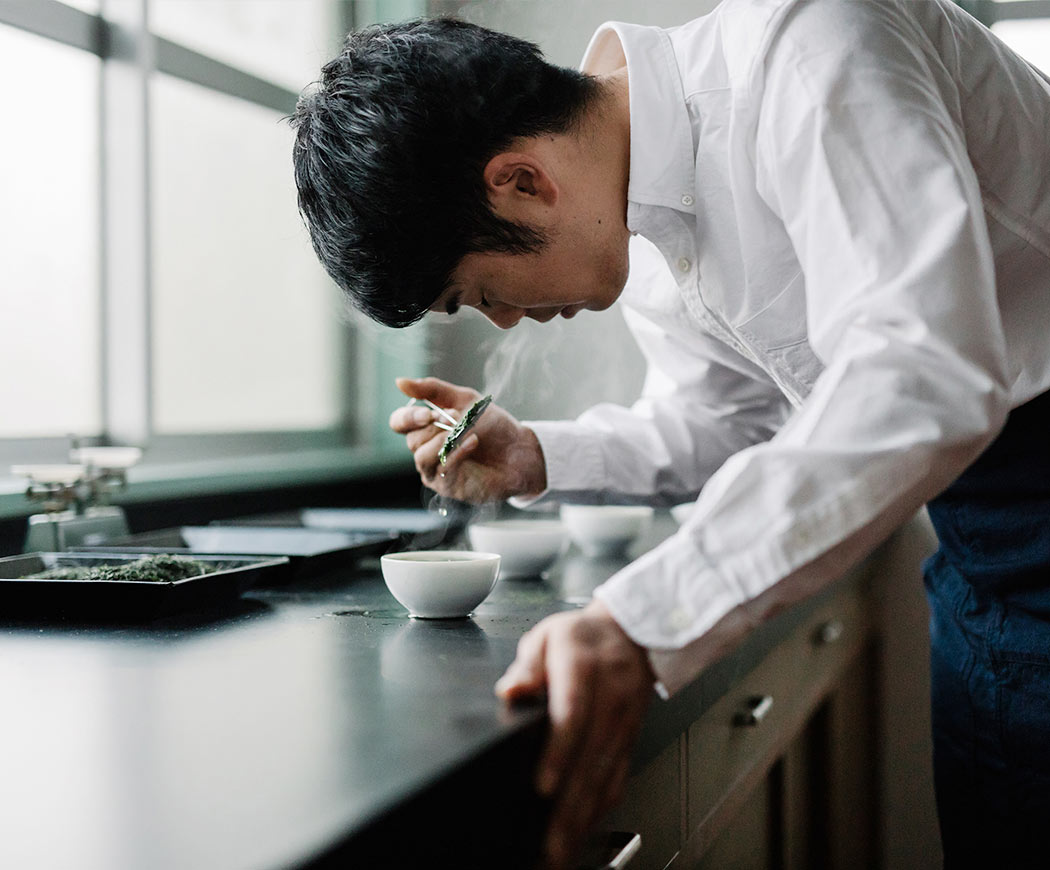 Person in a kitchen preparing food with a focus on culinary activity. Japan green tea master analyzing green tea, Uzuki producers