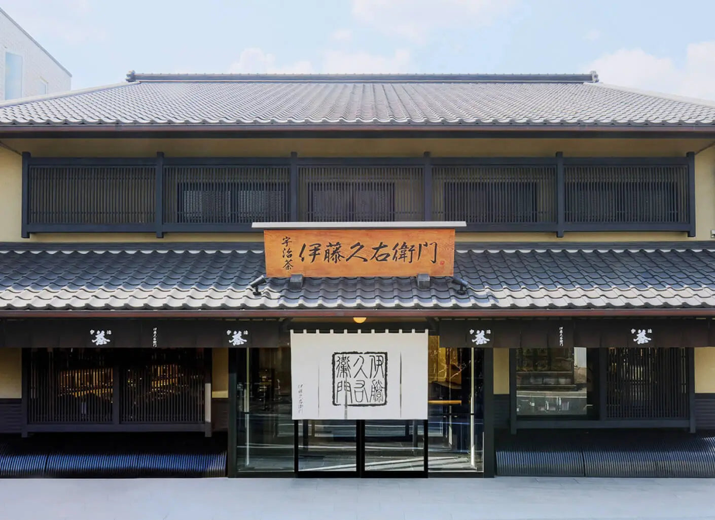 Traditional Japanese building with a signboard and white banner on a clear day. Green tae from Kyoto. Uji green tea. The best green tea from Japan. Uzuki 